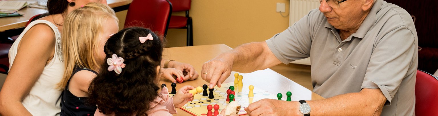 Bildausschnitt Menschen spielen Mensch ärgere dich nicht an einem Holztisch
