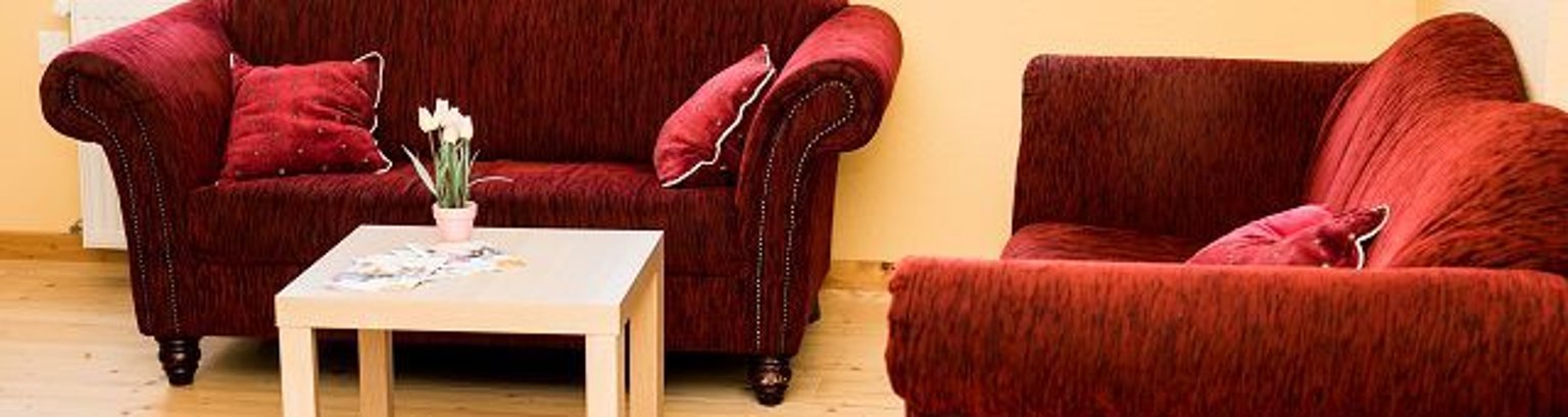 Beratung Jugendpflege zwei rote Sofas und ein kleiner Tisch