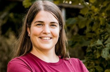 Portrait einer lächelnden Frau mit braunen langen Haaren